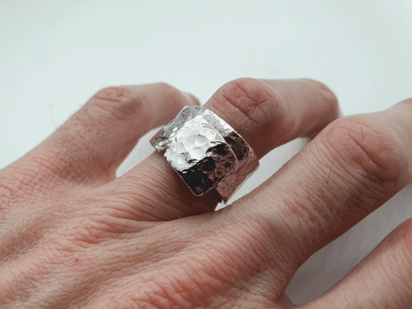 eon-20231221_175949 sterling silver ring with gentle arc and crater-textured surface