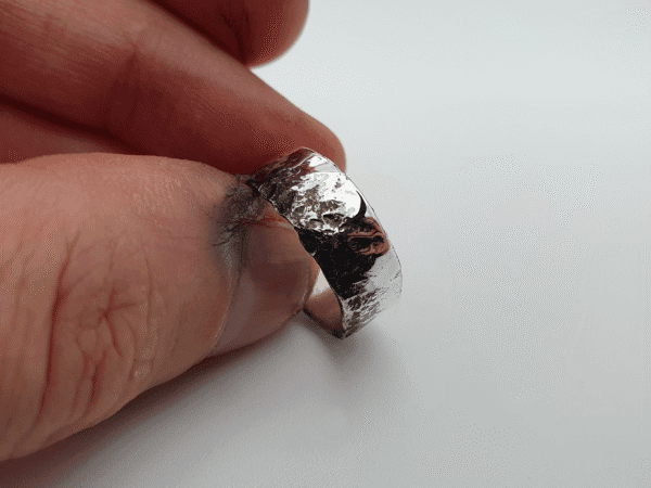onyxian-6 Close-up of Obscura ring showing intricate oxidised texture and reflective silver surface