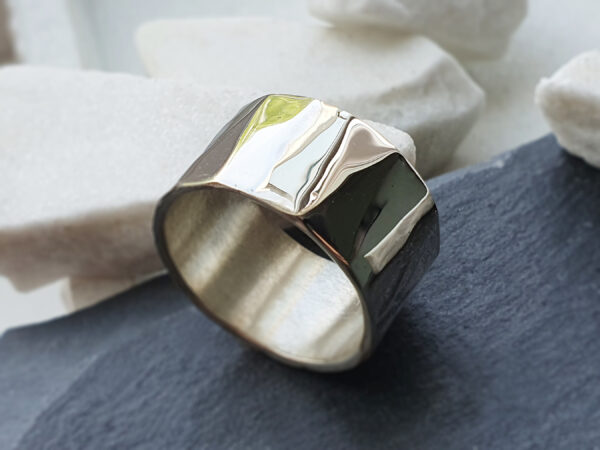 Prism ring product photo Wide silver prism ring on plain background